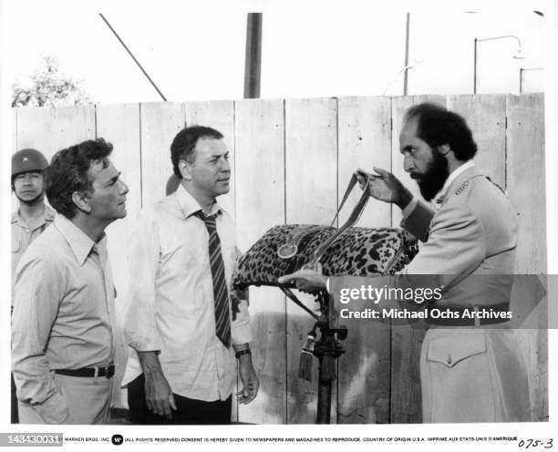 Peter Falk and Alan Arkin looks at a belt that Richard Libertini is show casing in a scene from the film 'The In-Laws', 1979.