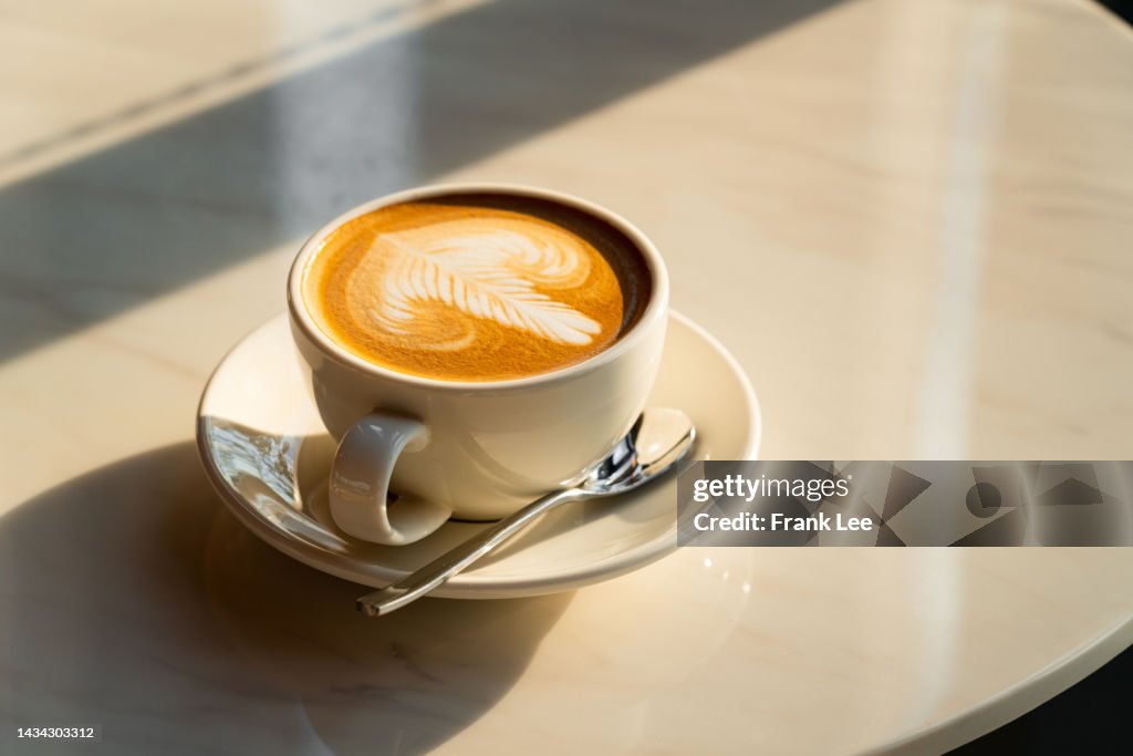 Feshly brewed latte coffee on a white table