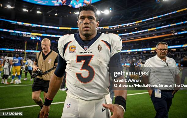 Russell Wilson of the Denver Broncos walks off the field after the fourth quarter of the Los Angeles Chargers 19-16 overtime win at SoFi Stadium in...