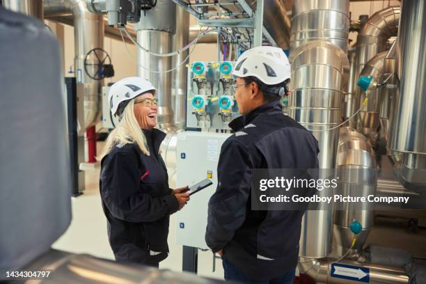 ingenieure lachen bei der gemeinsamen arbeit in einem kraftwerk - diversity people industry stock-fotos und bilder