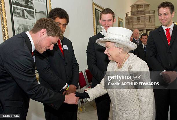 Britain's Queen Elizabeth II shakes hands with Welsh international rugby player Rhys Priestland as teammates Toby Faletau, Jonathan Davies and Ryan...