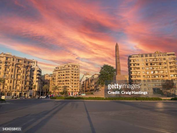 cairo tahrir square egypt at sunset with minimal traffic or people shot from the qasr el nil bridge. piazza & traffic circle, focus of unrest in the 2011 revolution & now home to the ramses ii obelisk. - road to war in middle east and north africa stock-fotos und bilder
