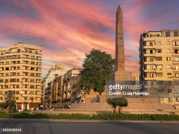 cairo tahrir square egypt at sunset with minimal traffic or people shot from the qasr el nil bridge. piazza & traffic circle, focus of unrest in the 2011 revolution & now home to the ramses ii obelisk. - road to war in middle east and north africa stock-fotos und bilder