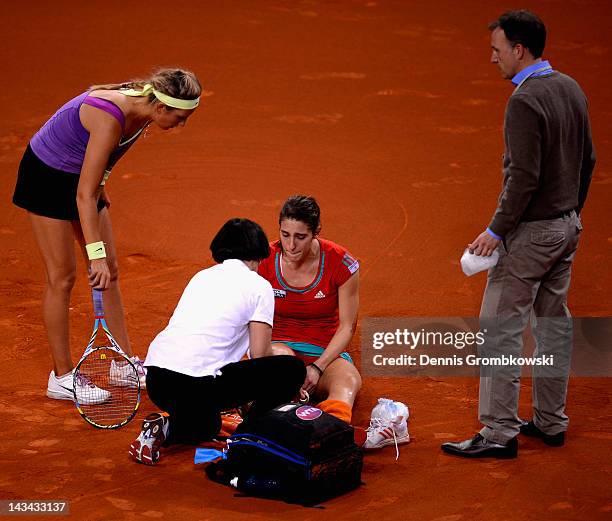 Andrea Petkovic of Germany sits on the court after suffering an injury in her match against Victoria Azarenka of Belarus during day four of the WTA...