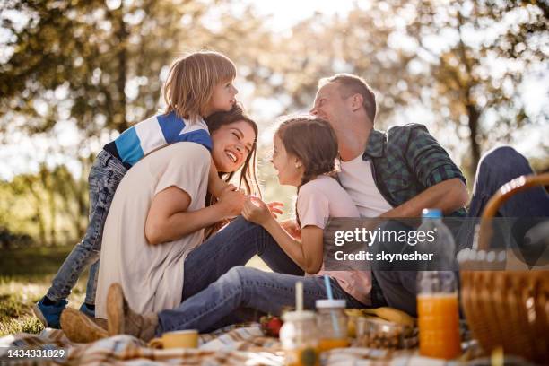 cheerful family having fun on a picnic in spring day. - family picnic stock pictures, royalty-free photos & images