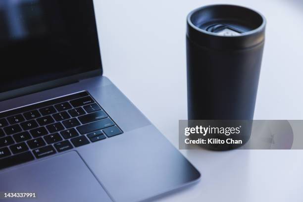 close-up of laptop and notebook on a desk - reusable coffee cup stock pictures, royalty-free photos & images