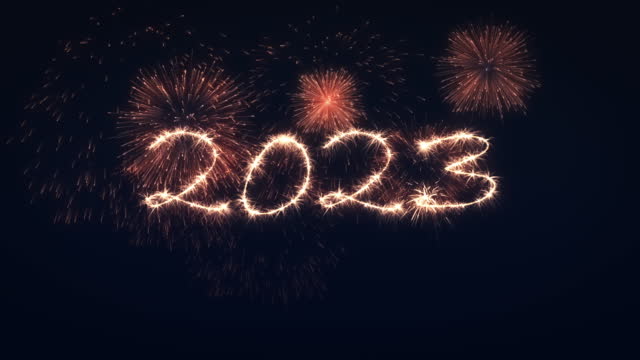 Happy New Year 2023 written with sparkler on black background and copy space for your logo