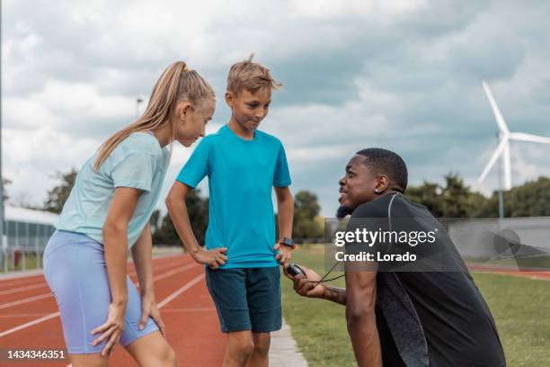 handsome black athletics coach and children - running netherlands stock pictures, royalty-free photos & images