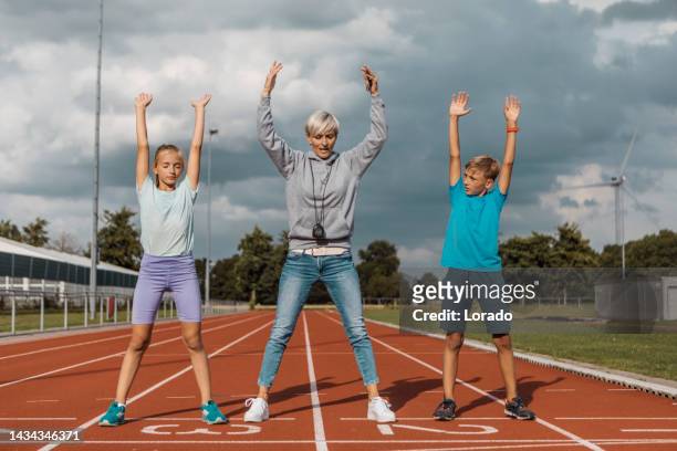 athletics mother running coach working with her children during a training session - soccer mom stock pictures, royalty-free photos & images