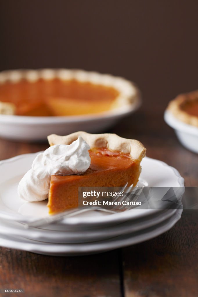 Plated slice of pumpkin pie with whipped cream