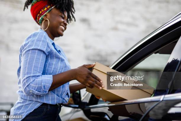 charming female delivery person giving customer their package at the curbside pickup - curbside pickup 個照片及圖片檔