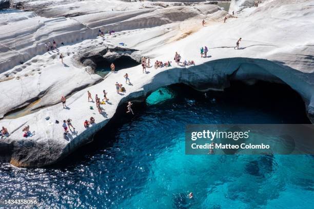 aerial view of tourists diving into the blue sea, milos, greece - milos stock pictures, royalty-free photos & images