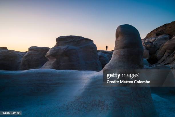 man standing amid white rocks at sunset, milos, greece - griechenland landschaft stock-fotos und bilder