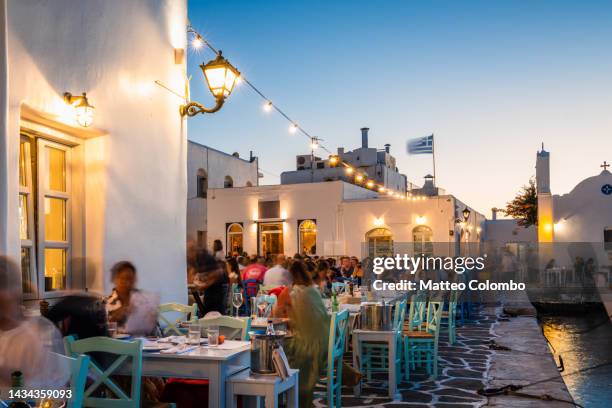 outdoor restaurants at naoussa harbor, paros, greece - greece city photos et images de collection