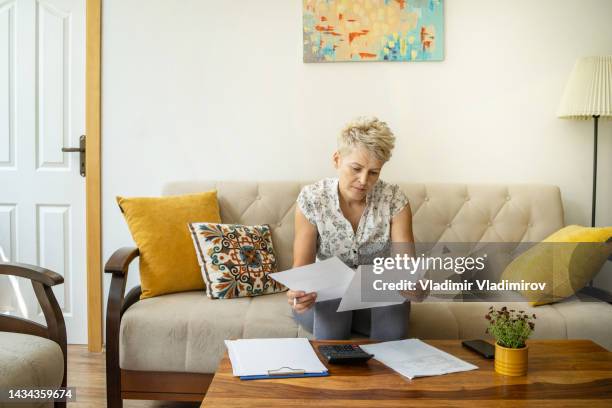 a woman looking at her home finances - tenant stock pictures, royalty-free photos & images