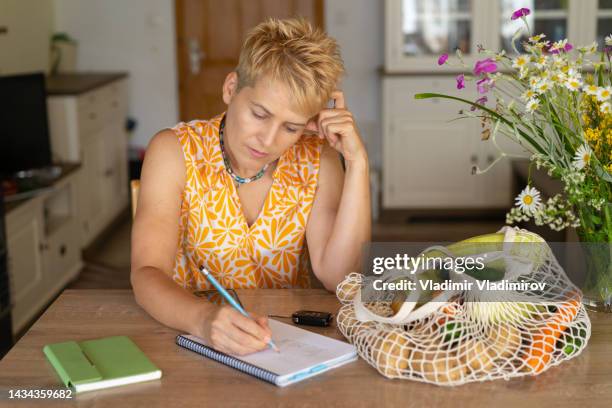 a woman calculating her spending - shopping list stock pictures, royalty-free photos & images