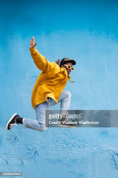 man in mid-air with arms outstretched - hip hopper stock pictures, royalty-free photos & images