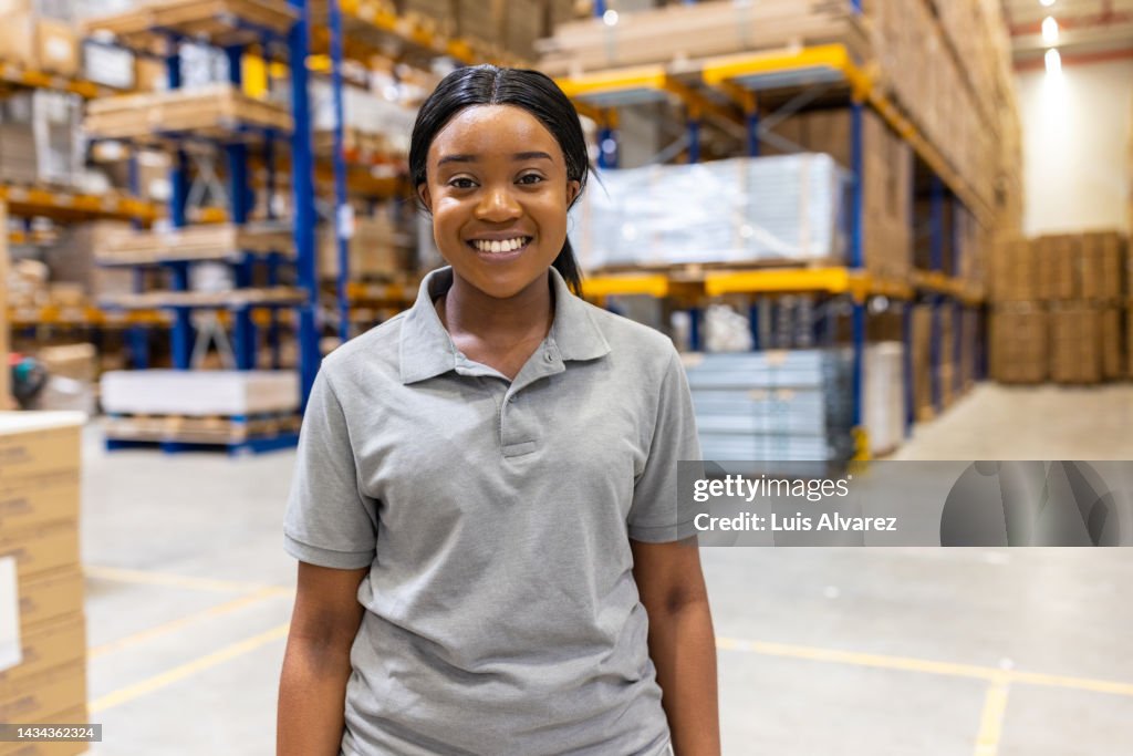 Portrait of a woman worker standing in warehouse