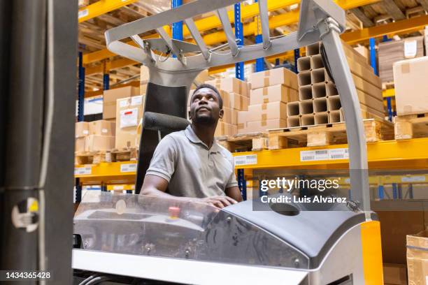 operator arranging boxes on the shelf with forklift loader - ware house worker forklift stock pictures, royalty-free photos & images