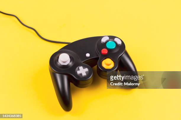 vintage gaming controller on yellow background. - controller stock pictures, royalty-free photos & images