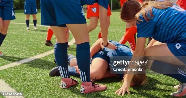 players gathering around injured player - soccer injury stock pictures, royalty-free photos & images