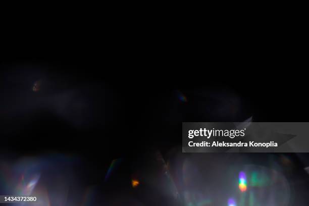 colourful rainbow light leaks texture on black background - rainbow lens flare stock pictures, royalty-free photos & images