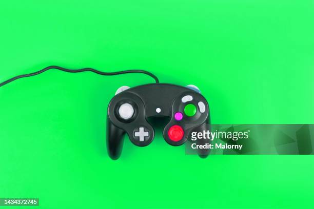 vintage gaming controller on green background. - manette photos et images de collection