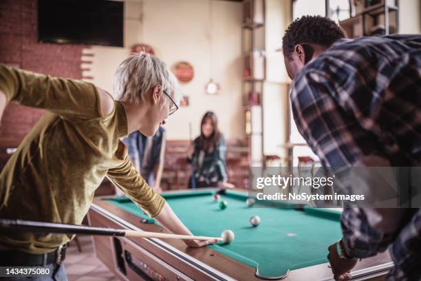 group of friends playing pool in the pub - poolbiljart stockfoto's en -beelden