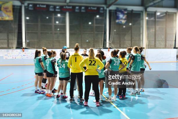 coach and female handball players planning a game - handbal stockfoto's en -beelden