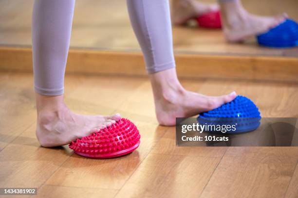 female feet touching massage ball - massagebal stockfoto's en -beelden