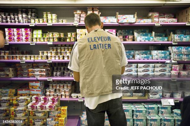 Un producteur de lait s'apprête à réétiqueter les produits laitiers des rayons d'un supermarché, le 03 août 2010 à Dijon, lors d'une action menée par...