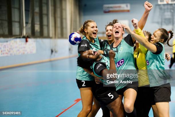 female handball players celebrating victory after match - handbal stockfoto's en -beelden