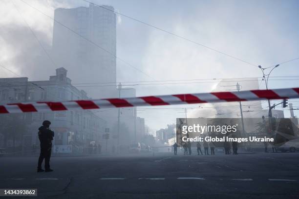 Policeman stands behind red-and-white warning tape at an area which was attacked by “kamikaze drones” on October 17, 2022 in Kyiv, Ukraine. Five...