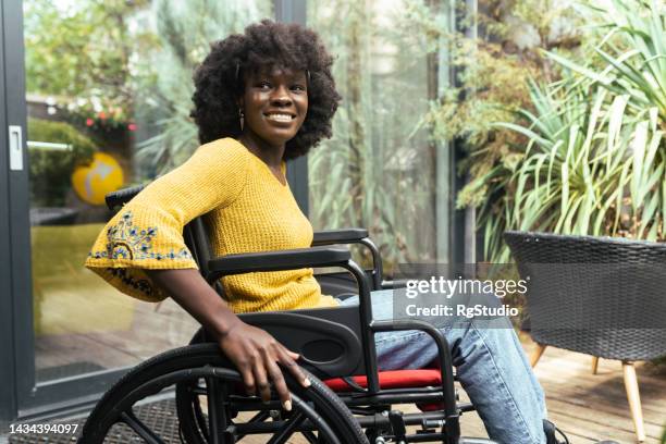 retrato de una joven africana en silla de ruedas disfrutando en el porche - personas-de-color fotografías e imágenes de stock