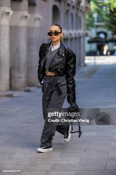 Anna Idriess wears black cropped leather jacket Storets, grey pants Storets, white cropped blouse Source Unknown, grey cropped jumper Mango, white...