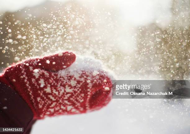red knit mittens and flying snowflakes - woman hands in mittens stock-fotos und bilder