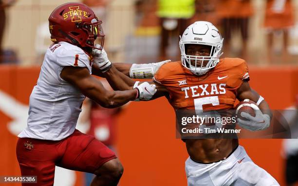 Bijan Robinson of the Texas Longhorns runs the ball while defended by Anthony Johnson Jr. #1 of the Iowa State Cyclones in the first half at Darrell...