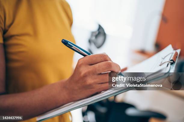 woman hand writing on clipboard with a pen. - lijst document stockfoto's en -beelden