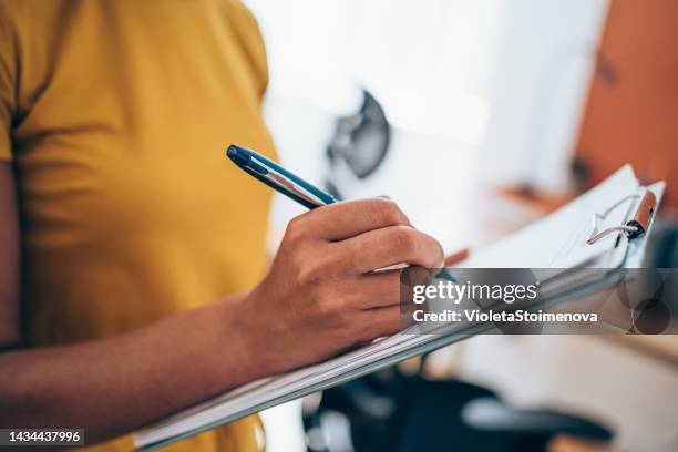 woman hand writing on clipboard with a pen. - human body part stockfoto's en -beelden