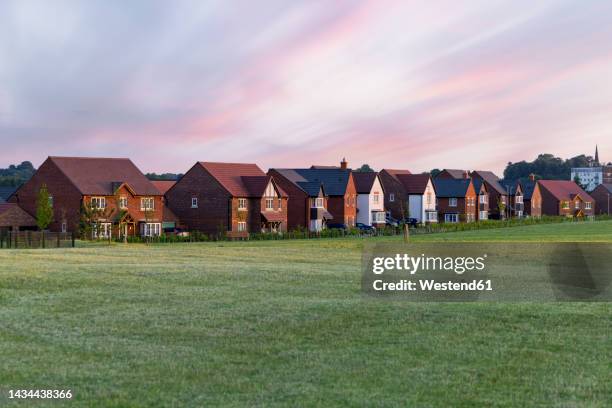 grass area by residential houses under clouds at sunset - lichfield stock pictures, royalty-free photos & images