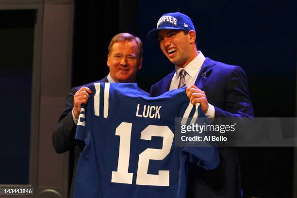 Andrew Luck from Stanford holds up a jersey as he stands on stage with NFL Commissioner Roger Goodell after Luck was selected overall by the...