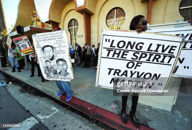 Rally attendees hold signs at the entrance of West Los Angeles Church in Christ during a rally to mark the two-month anniversary of Trayvon Martin's...