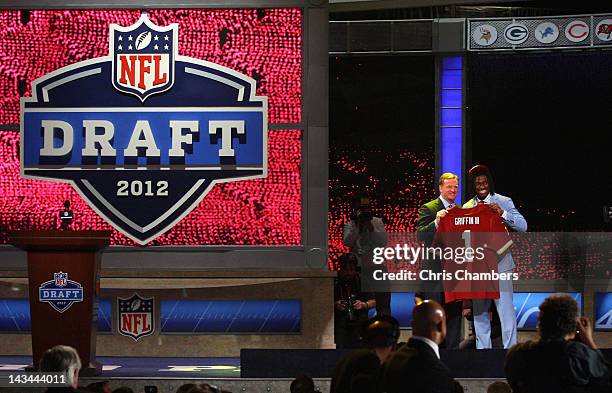 Robert Griffin III from Baylor holds up a jersey as he stands on stage with NFL Commissioner Roger Goodell after Griffin was selected overall by the...