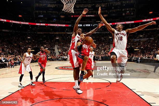 Sundiata Gaines of the New Jersey Nets goes to the basket against Ed Davis and Ben Uzoh of the Toronto Raptors on April 26, 2012 at the Air Canada...