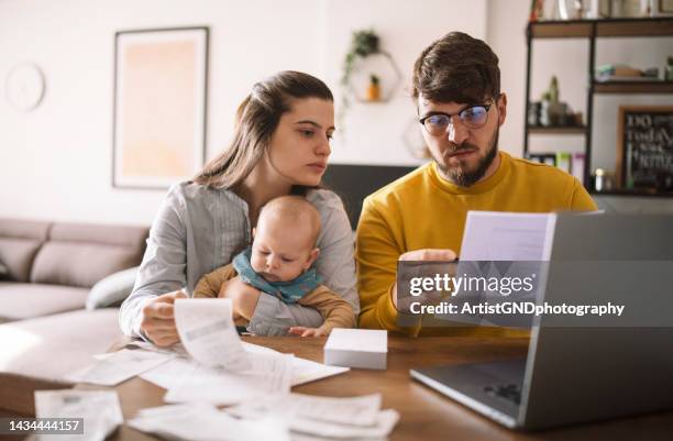 junge familie, die das budget verwaltet und rechnungen und steuern bezahlt. - rechnungen stock-fotos und bilder