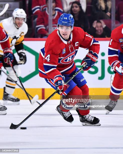 Nick Suzuki of the Montreal Canadiens skates the puck against the Pittsburgh Penguins during the second period at Centre Bell on October 17, 2022 in...