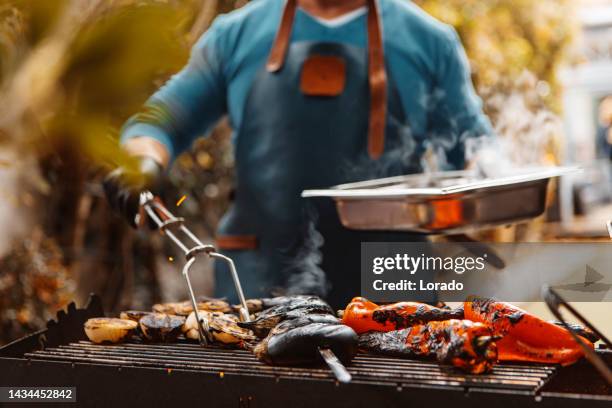 unknown man preparing bbq food on an outdoor grill - grill party stockfoto's en -beelden