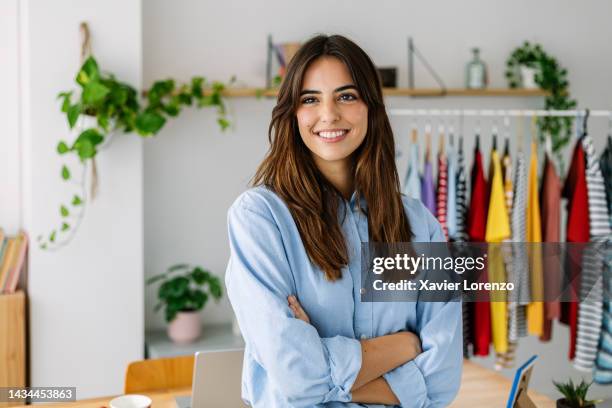 portrait of confidence young adult small business female owner standing at clothing store - saleswoman stock pictures, royalty-free photos & images