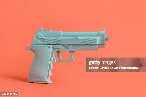 blue handgun on red background - feuerwaffen abzug stock-fotos und bilder