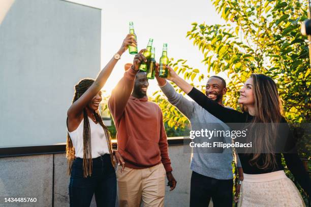 friends are toasting together with beers - burberry and fox searchlight pictures honour the cast and filmmakers of brooklyn stockfoto's en -beelden